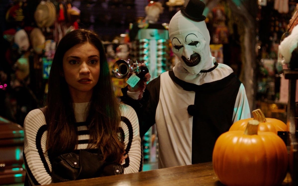 Sienna (Lauren LaVera) and Art the Clown (David Howard Thornton) stand next to each other in a Halloween store in a scene from Terrifier 2