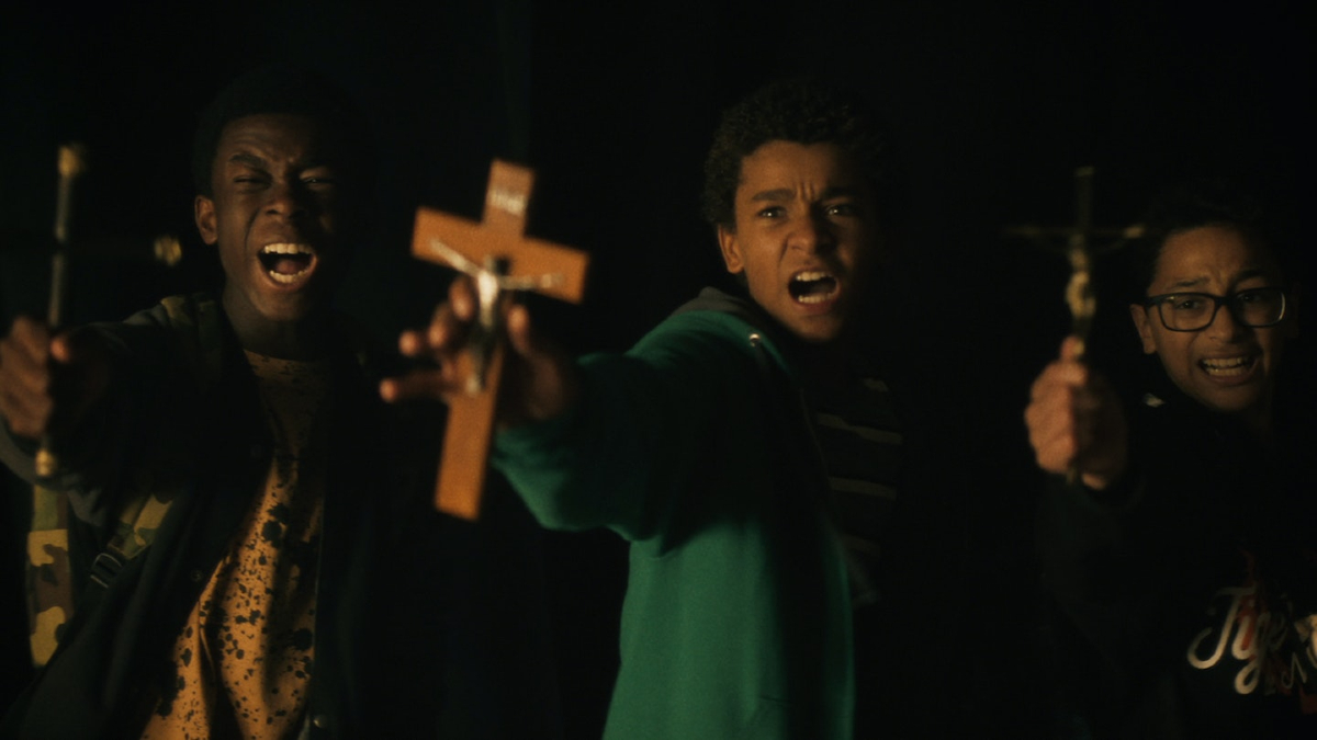 Three Black kids hold up crosses while shouting to ward off predatory vampires in 'Vampires vs. the Bronx'