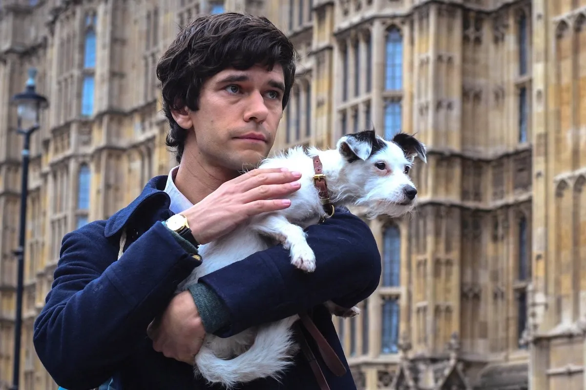 Ben Whishaw holds a small dog in a scene from A Very English Scandal