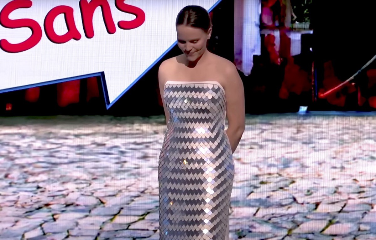 A woman in a dress covered in scale-like display screens.