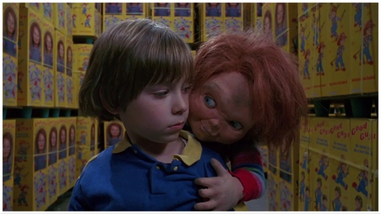 Chucky rides on Andy's (Alex Vincent) back as they are surrounded by boxes of Good Guy dolls in 'Child's Play 2'. 