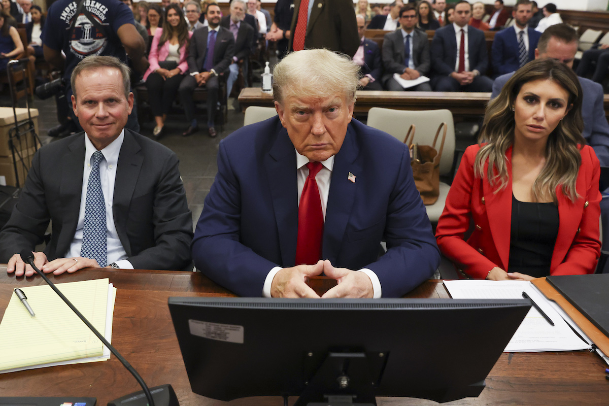 Donald Trump stares into the camera, sitting in court.