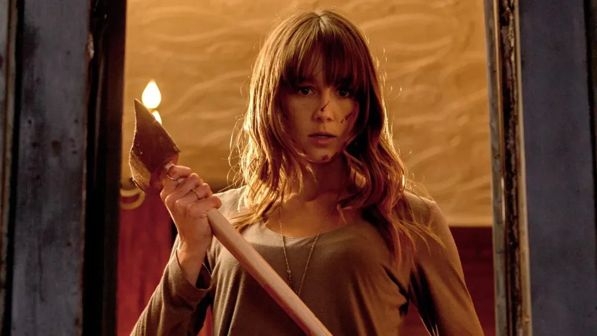 A young woman holds an ax in "you're next"