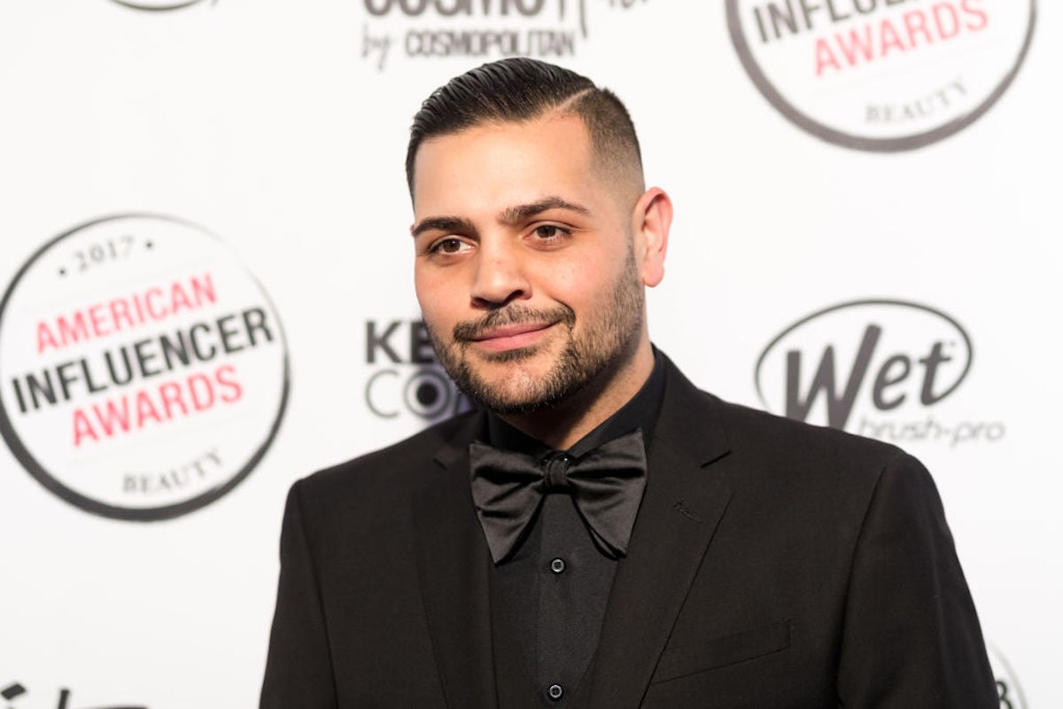 Michael Costello stands in front of a white backdrop.