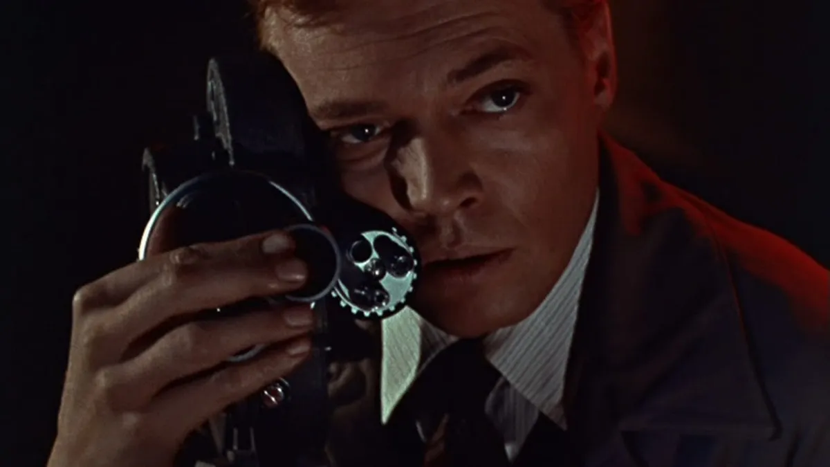 A creepy man caresses his film camera in "Peeping Tom" 