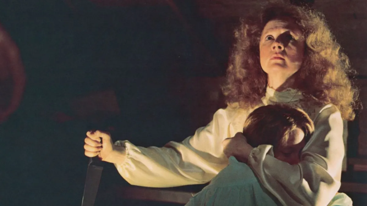 Piper Laurie hugs Sissy Spacek with one hand while wielding a knife in the other in 'Carrie'.