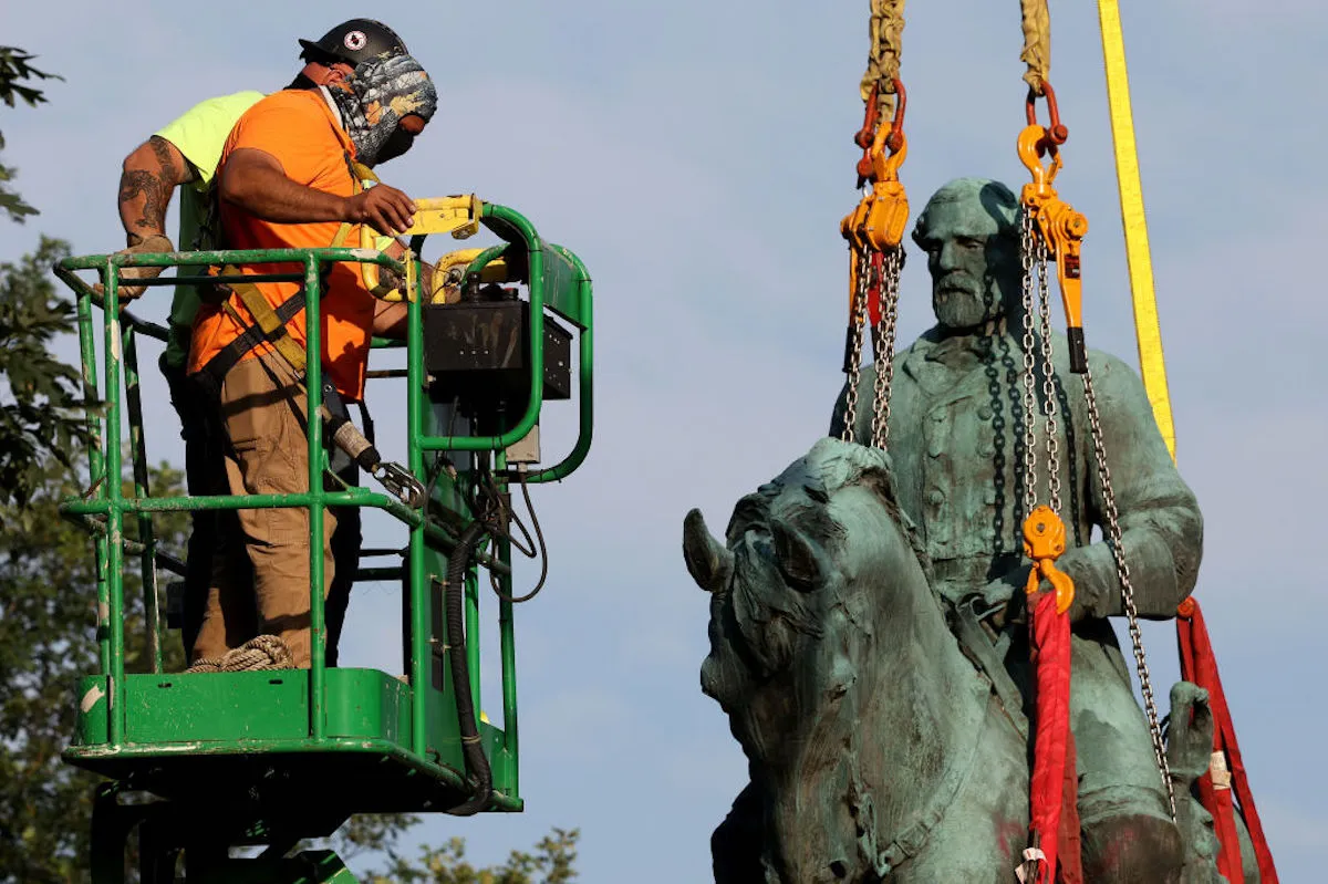Workers remove a statue of Confederate General Robert E. Lee in Charlottesville, Virginia