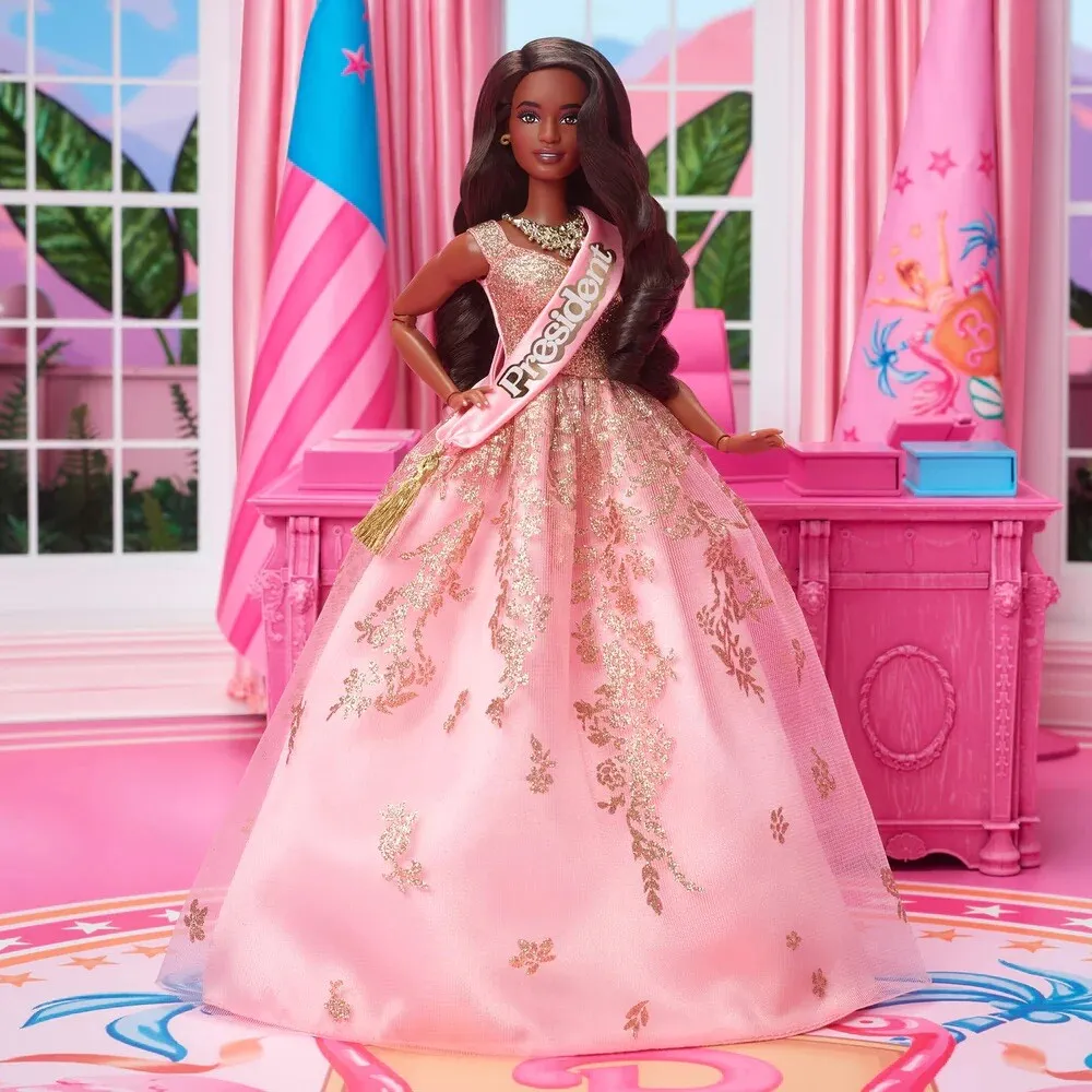 President Barbie: A Black Barbie wears a gold and pink gown while standing in a pink and blue Oval Office