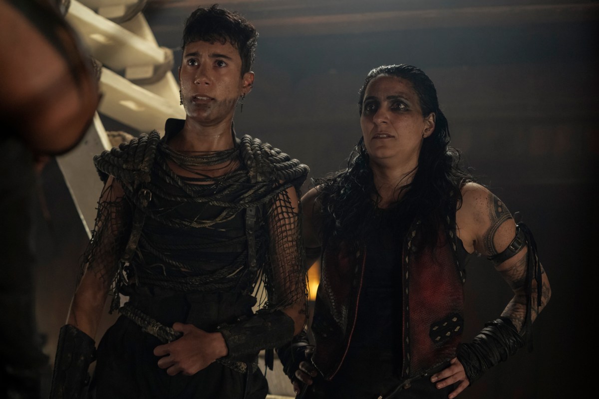 Jim and her crewmate stand aboard the Revenge. They both have face paint on, and cool leather outfits.