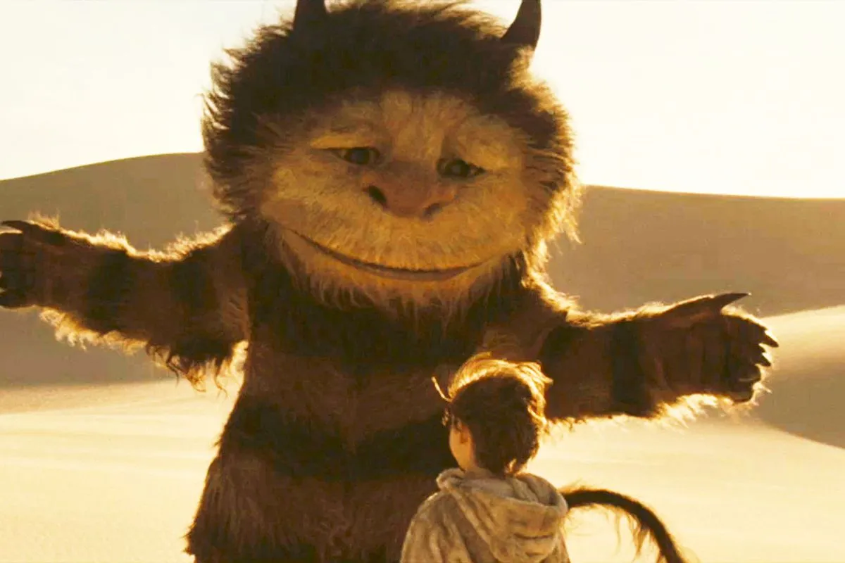 A furry monster stretches its arms in front of a young boy in "Where The Wild Things Are"