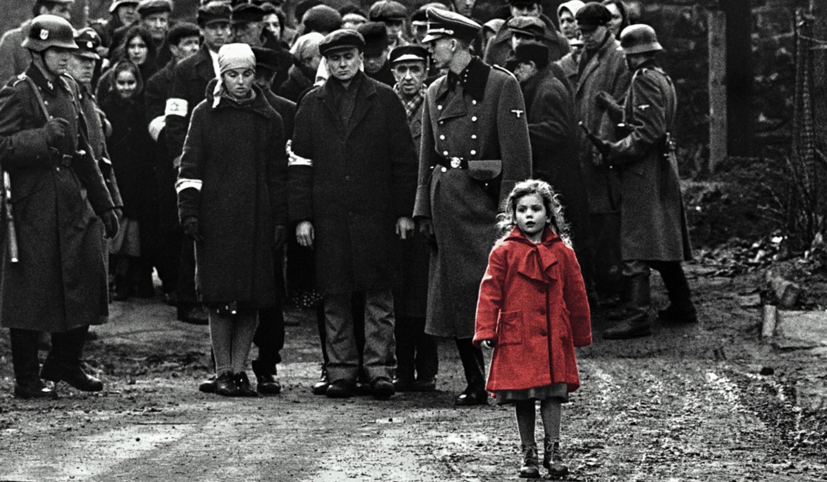 A little girl in a red coat walks in front of soldiers in the film 'Schindler's List'