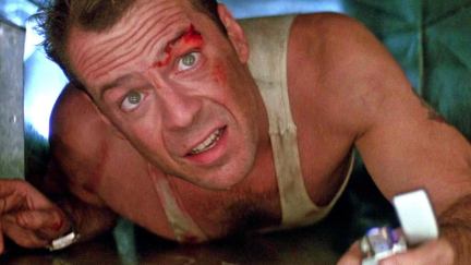 A white man with cuts on his face crawls through a vent in 'Die Hard.'