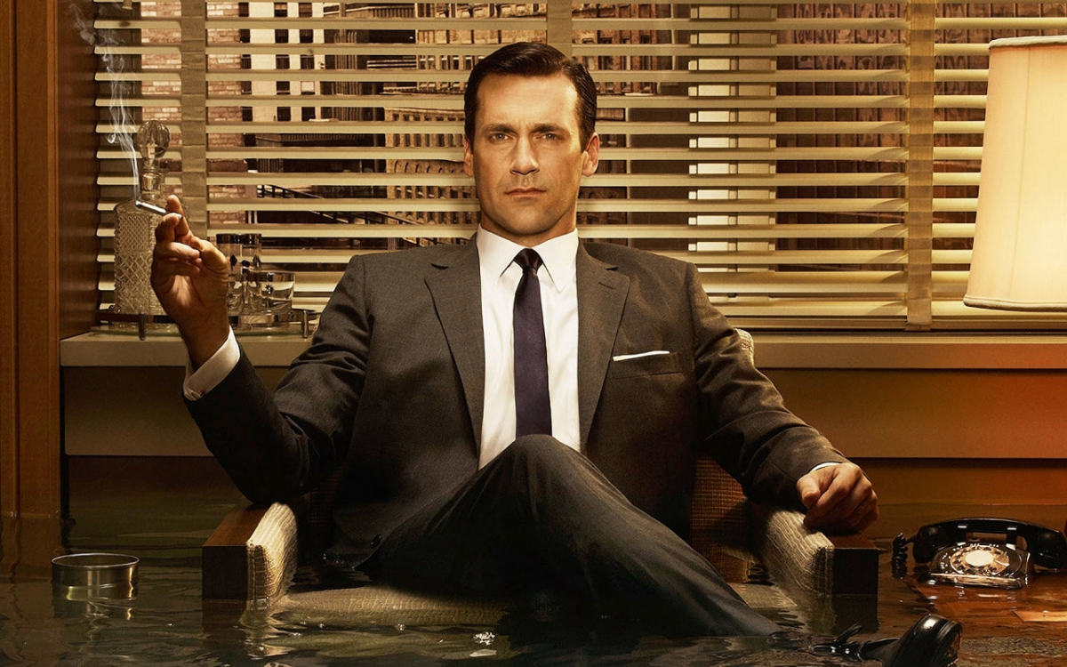 Jon Hamm wears a vintage suit and sits in an office chair floating in water in an advertisement for AMC's 'Mad Men'.