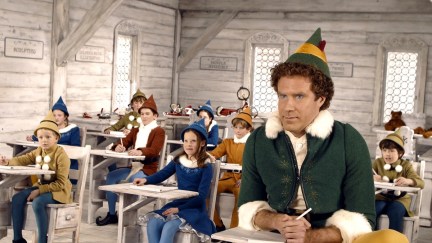 large man in elf costume sits in classroom with much smaller children/elves