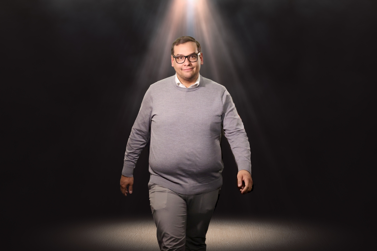 George Santos stands in the spotlight.