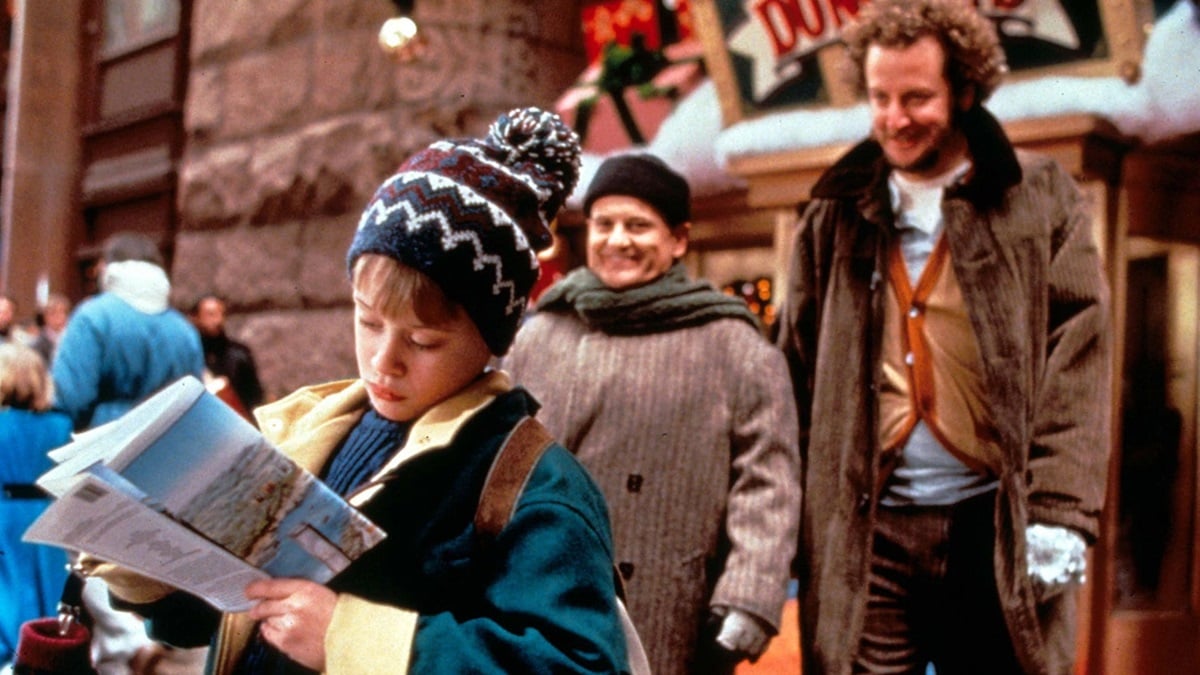 two robbers leer at Kevin McCallister as he reads a map