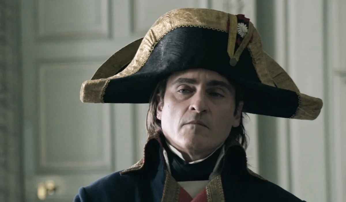 Napoleon (Jaoquin Phoenix) glares at someone while wearing his iconic bicorne hat.