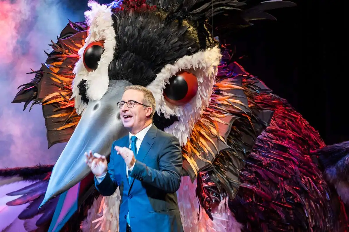 John Oliver stands in front of a giant bird puppet in 'Last Week Tonight.'