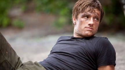 Josh Hutcherson as Peeta Mellark, a man leans back on the ground in 'The Hunger Games.'