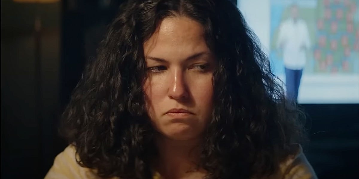 Image of Laura Galan (Sara) in a scene from 'Piggy.' She is a fat white teenager with thick, curly, shoulder-length black hair. She is angrily averting her eyes.