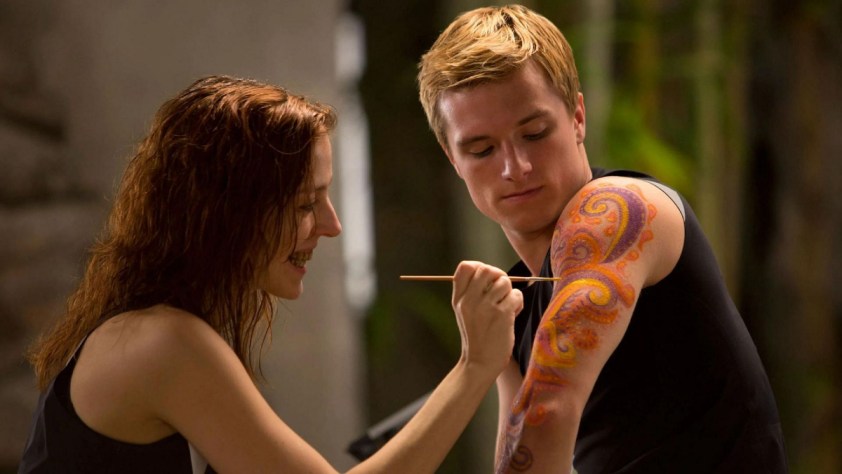 Megan Hayes as a Morphling gives Josh Hutcherson's Peeta a hand drawn tattoo in 'The Hunger Games'