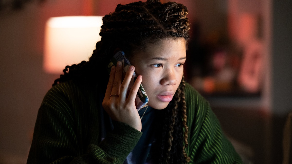 a girl (Storm Reid) holds phone to her ear and gazes intently at a computer screen