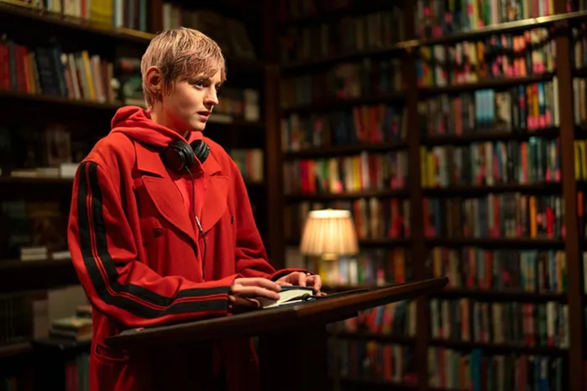 woman in red hoodie giving a reading in a bookstore