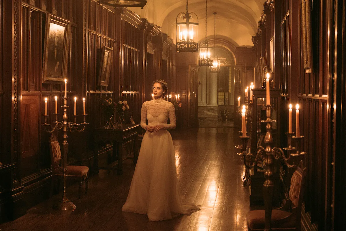 young bride stands in a long hall in a mansion. Ready or Not movie.