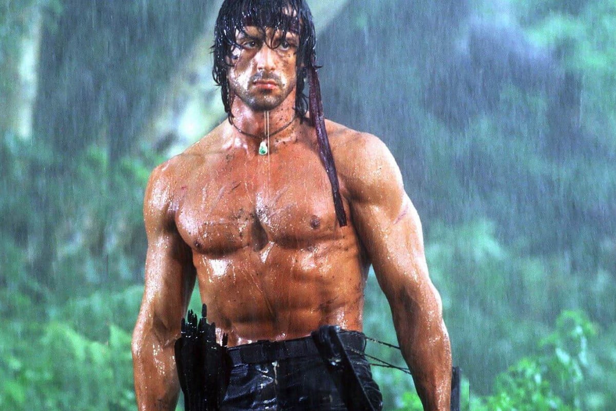 Sylvester Stallone in Rambo First Blood Part II, standing in the rain in the jungle.