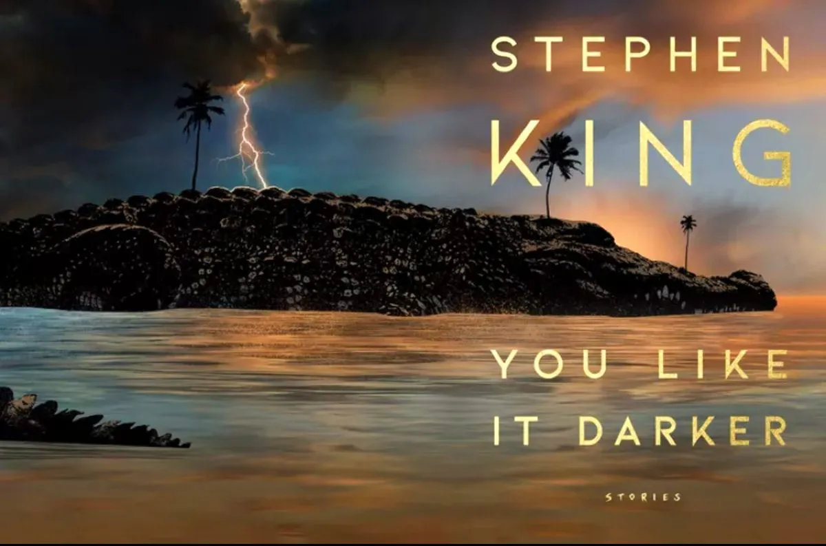 A large alligator floats in water under a stormy sky on the cover of 'You Like It Darker' by Stephen King.