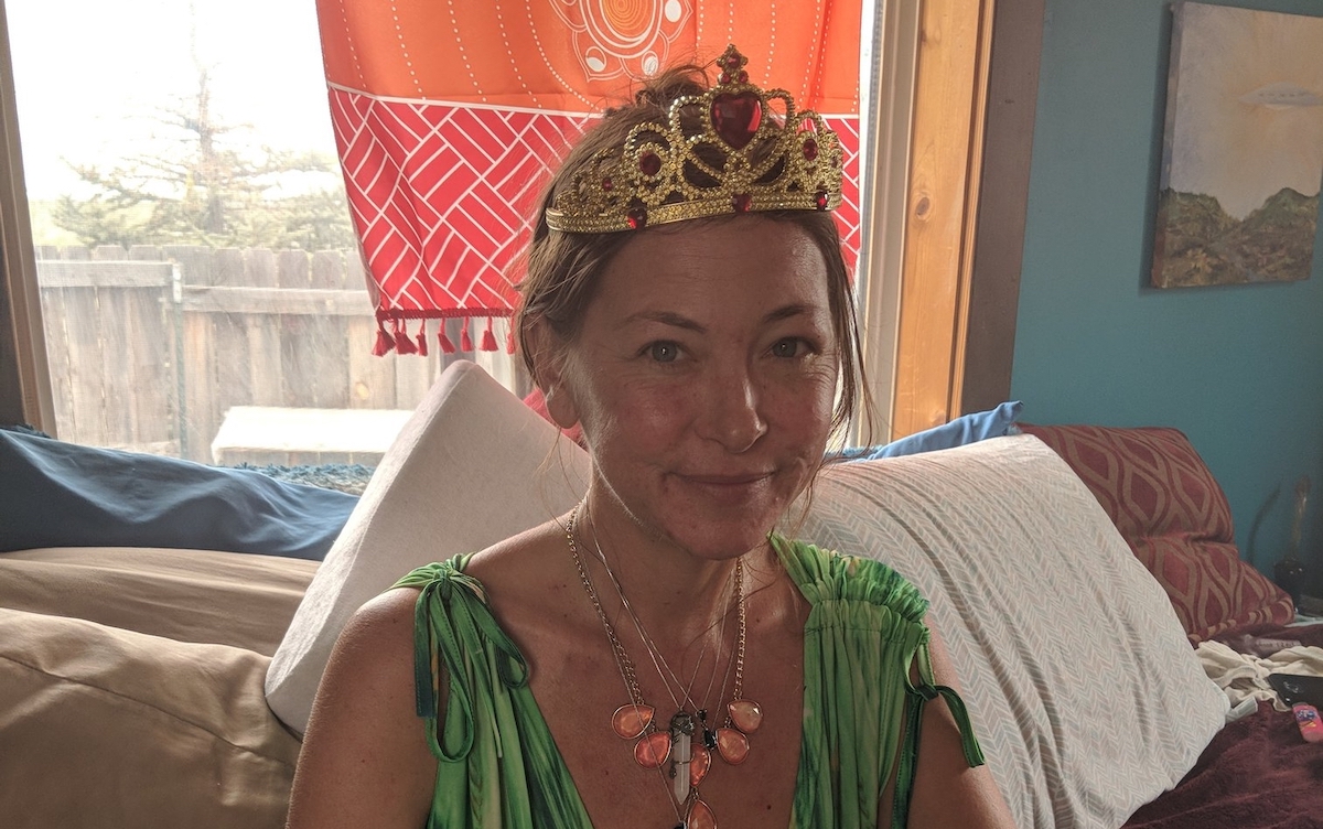 Amy Carlson, a.k.a. Mother God, poses in a green ball grown and tiara.