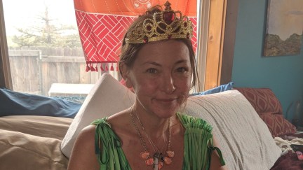 Amy Carlson, a.k.a. Mother God, poses in a green ball grown and tiara.