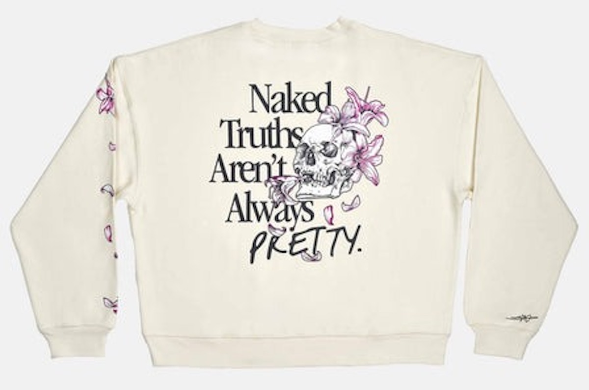 A white sweatshirt with a skull and flowers design and the words Naked truths aren't always pretty."