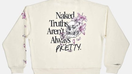 A white sweatshirt with a skull and flowers design and the words Naked truths aren't always pretty.