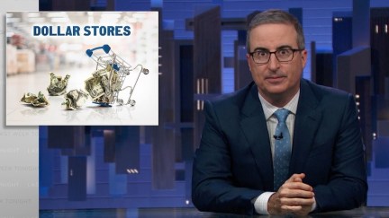 John Oliver sits at his news desk with a graphic on screen reading 