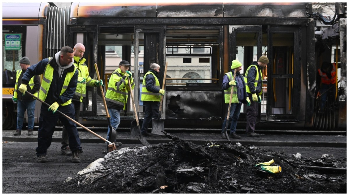 DUBLIN, IRELAND - NOVEMBER 24: Workers clean up the debris of a burnt train on November 24, 2023 in Dublin, Ireland. Vehicles were set alight and shops looted in Dublin last night, following a knife attack outside a school that left five people, including three children, injured.