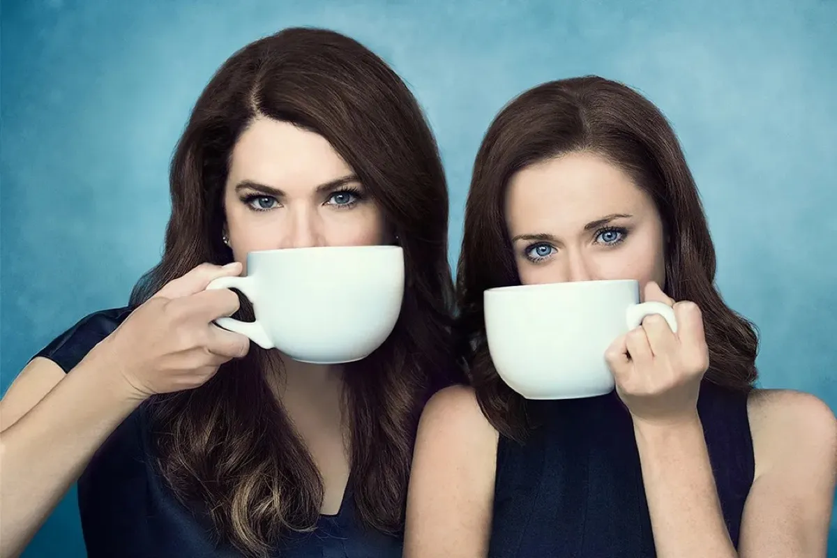 The Gilmore Girls, drinking coffee, allegedly, in promo art for Netflix's Gilmore Girls: A Year in the Life.