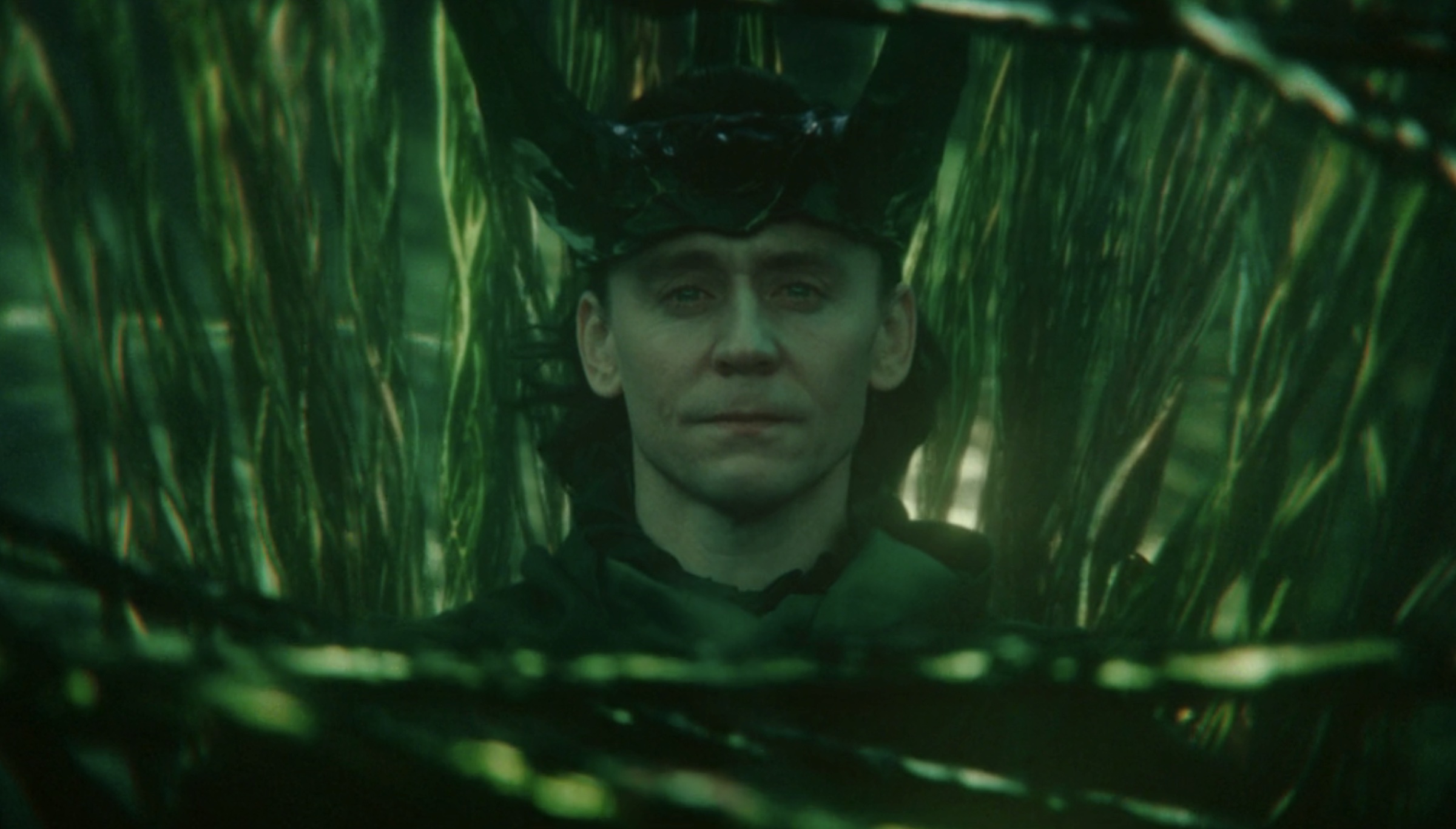 Loki wears a new crown of horns, surrounded by green strands of time.