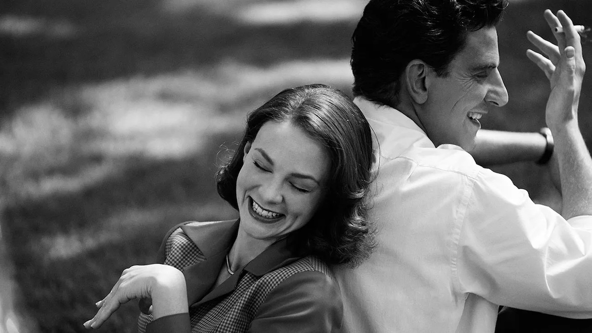 Leonard and Felicia sit back to back in the grass in Maestro.