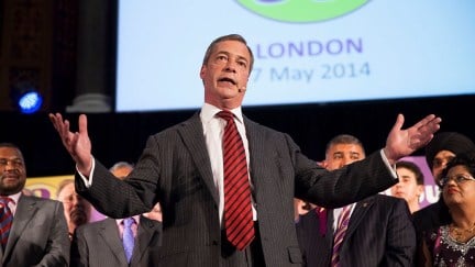 Nigel Farage making a doofusy gesture while speaking at an event.