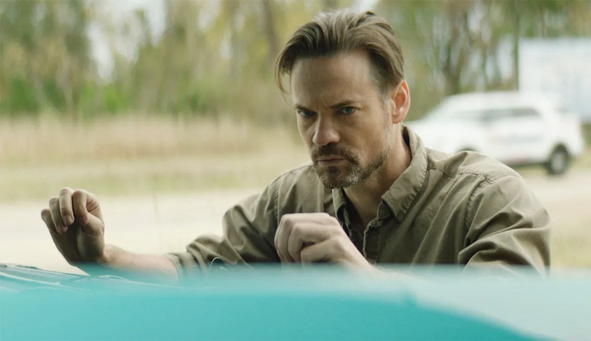 Shane West standing at a car in The Dirty South