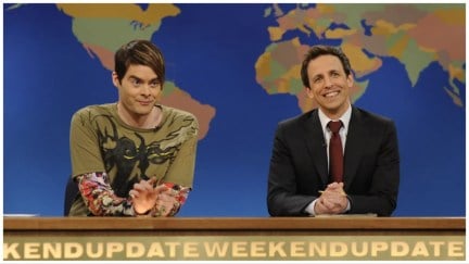 Stefon (Bill Hader) sits at a desk next to 'Weekend Update' anchor Seth Meyers on 'Saturday Night Live'.