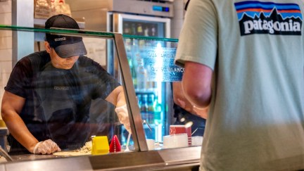 A Chipotle employee attends to a customer