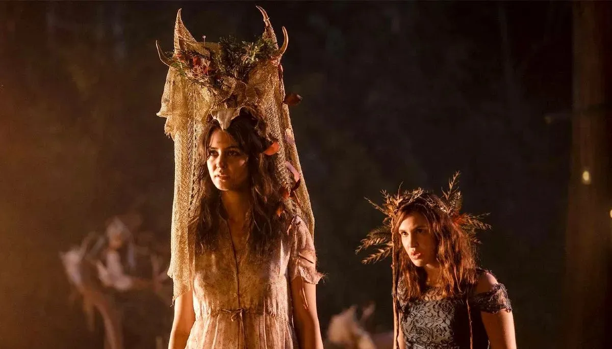 Courtney Eaton as Lottie and Sophie Nelisse as Shauna prepare for a feast in 'Yellowjackets.'