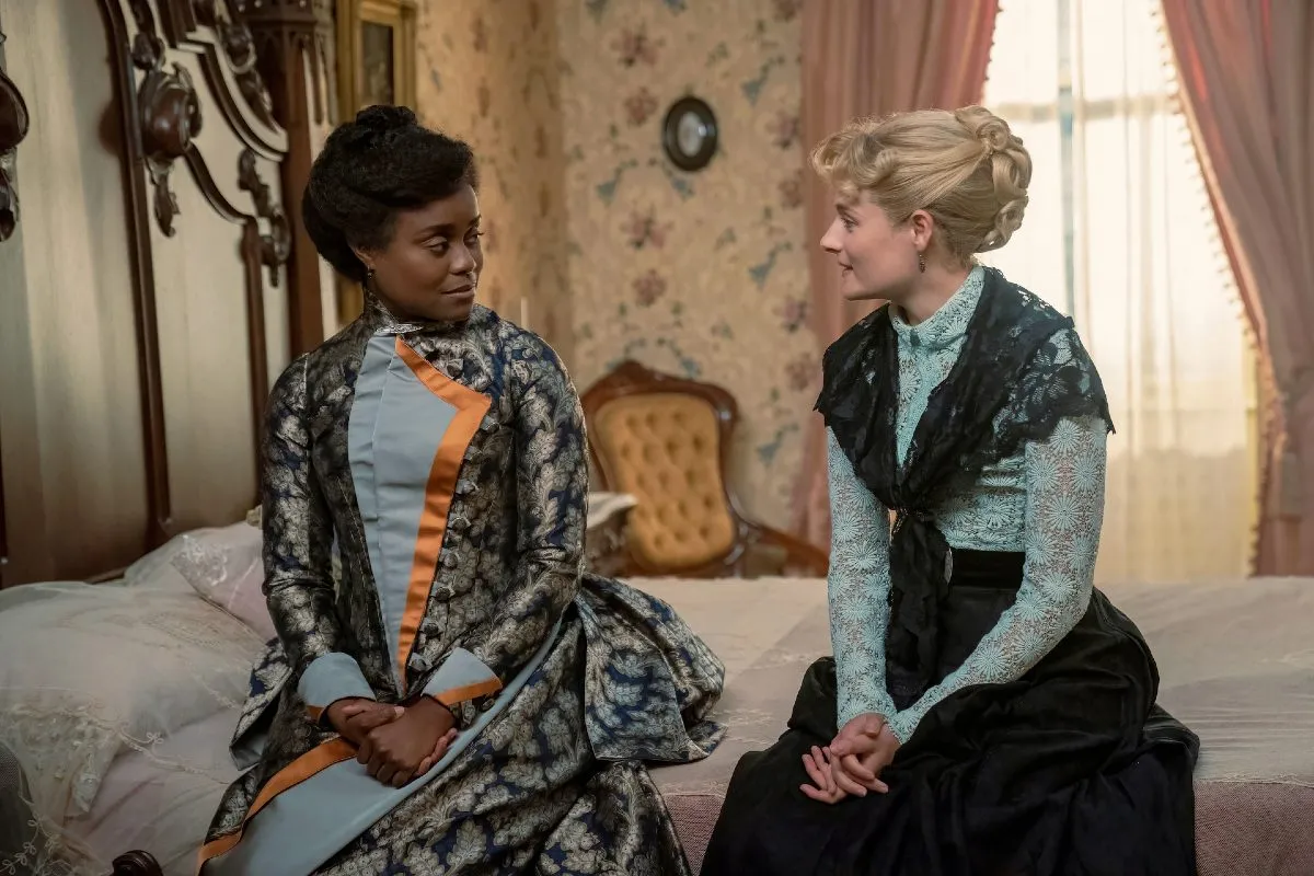 Peggy Scott and Marian Brook sit on a bed talking in 'The Gilded Age' season 2.