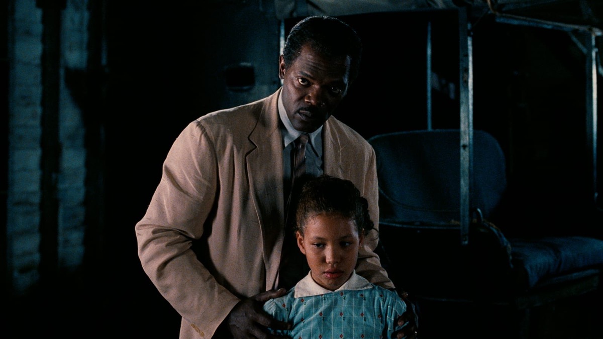 A little girl stands morosely while her father holds her shoulders in "Eve's Bayou" 