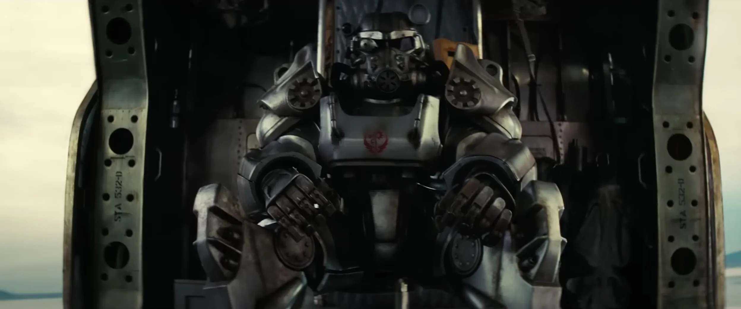 Screencap of someone in Brotherhood of Steel armor in the 'Fallout' show. They are sitting in a Vertibird. 