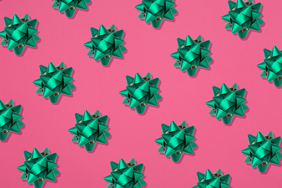 Green holiday gift bows on a pink background