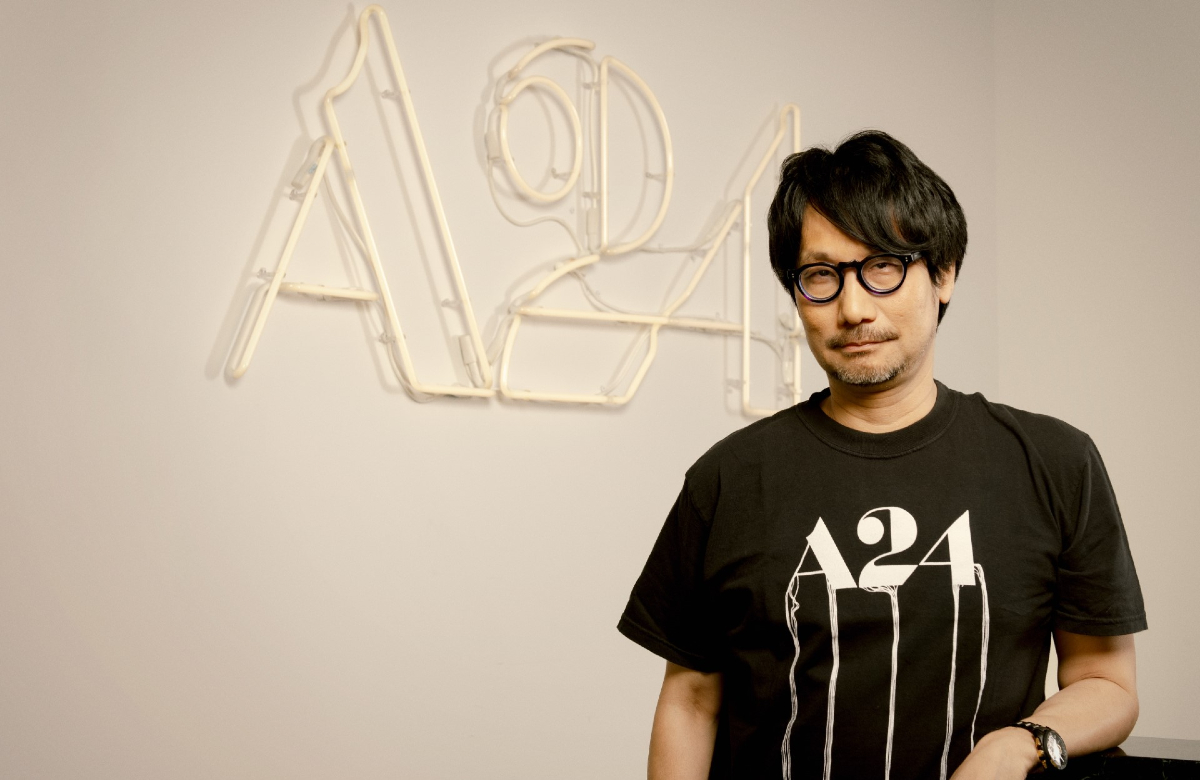 Hideo Kojima poses in an A24 t-shirt at the A24 offices