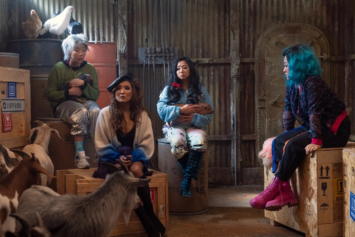 The girls sitting in a shed surrounded by farm animals in Joy Ride